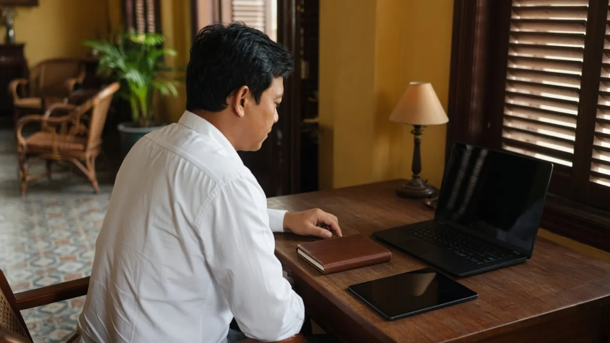 Nhân viên khách sạn làm việc với laptop tại sảnh cổ, gợi ý chiến lược SEO website tăng đặt phòng trực tiếp.